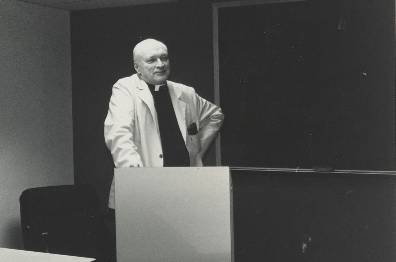 Black and white photo of Fr. Haig teaching in the classroom